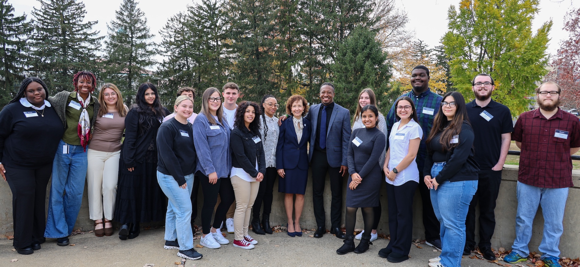 A large group of scholarship recipients posing outside with donors and the President