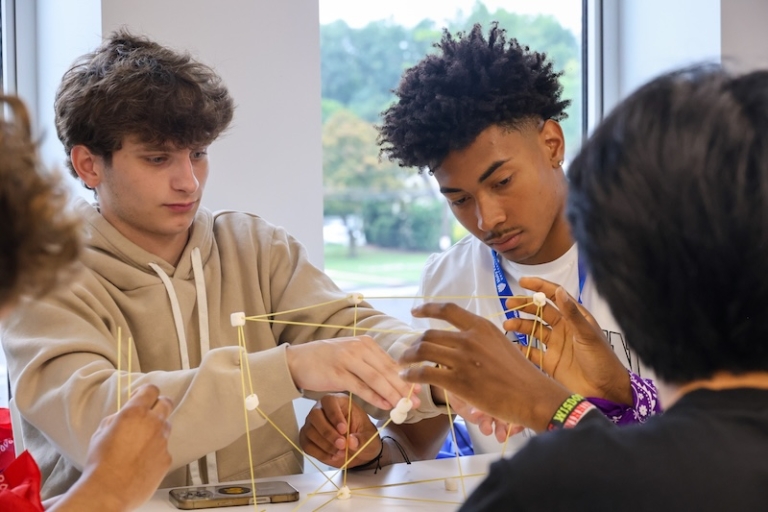 Students gathered around table working on a science project