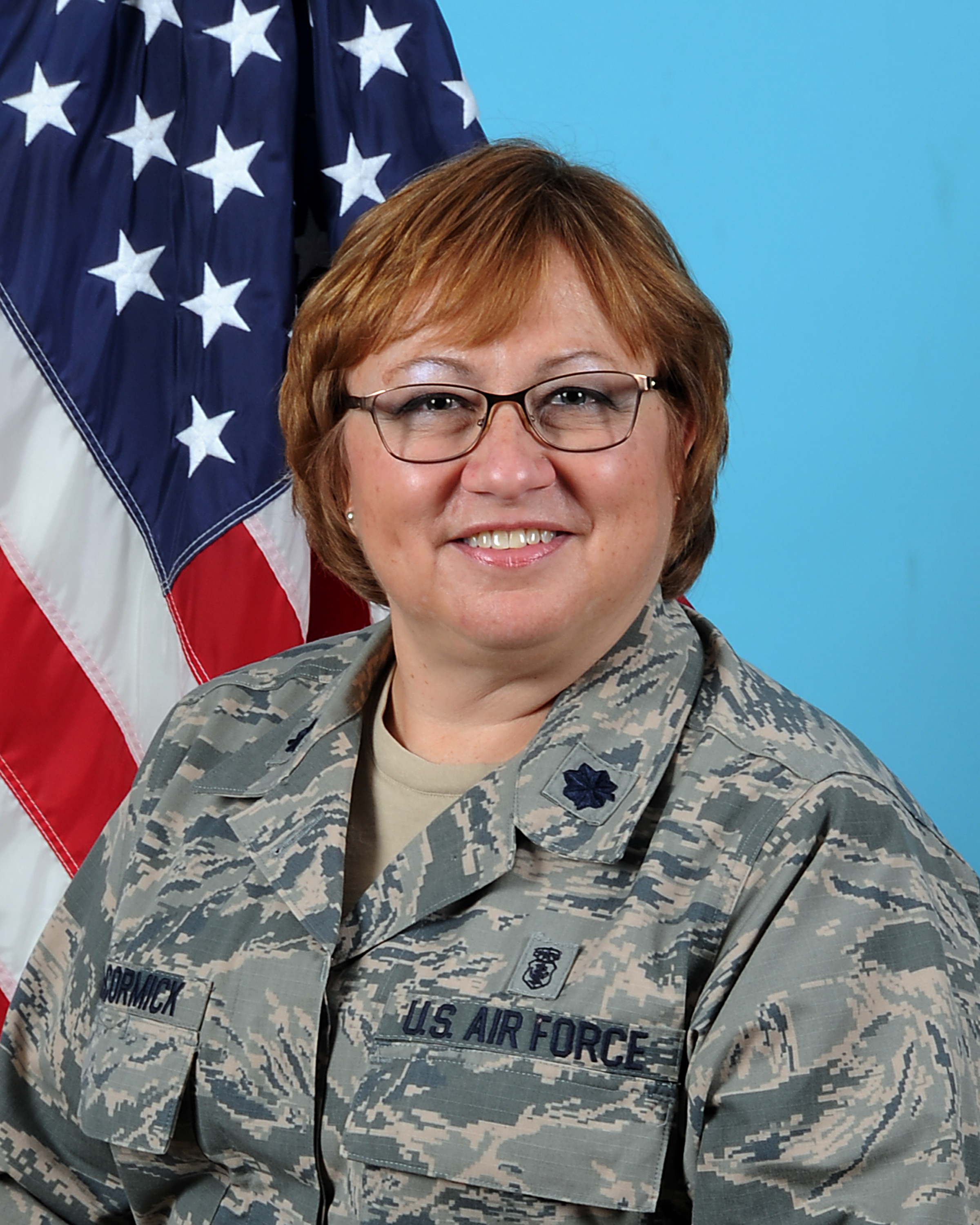 McCormick-Mejias's military headshot in uniform in front of American flag