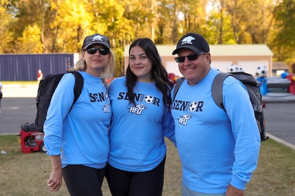 Holy Family student and her parents all smiling and wearing Holy Family University shirts