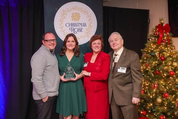 Alum receiving an award at the University's annual Christmas Rose ceremony