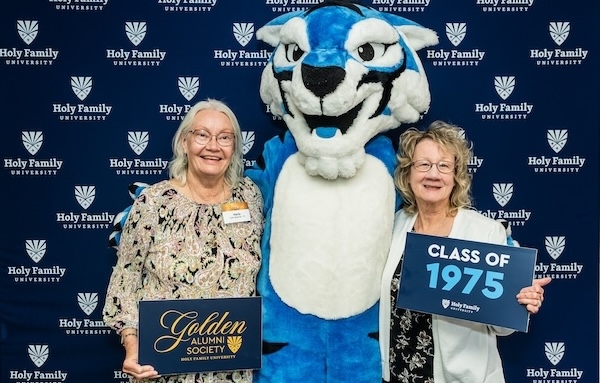 Two alumni poses with Blue the mascot at the Golden Alumni Reunion 2025