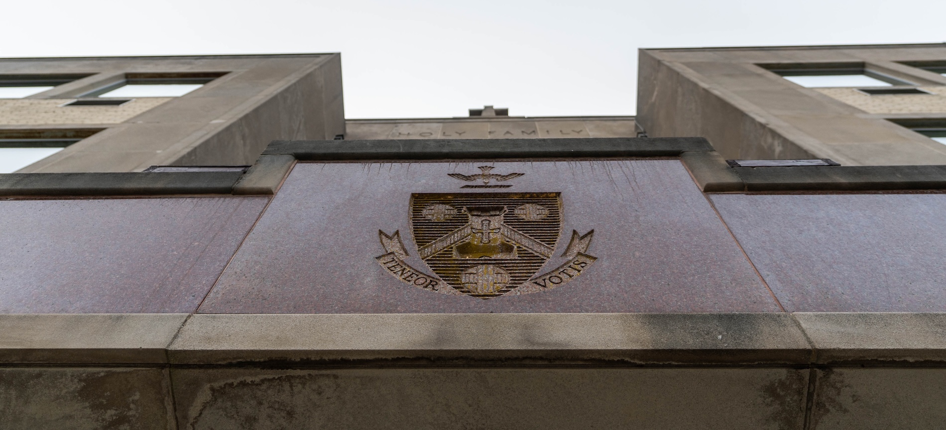 The exterior facade of an HFU building with the University seal engraved on it