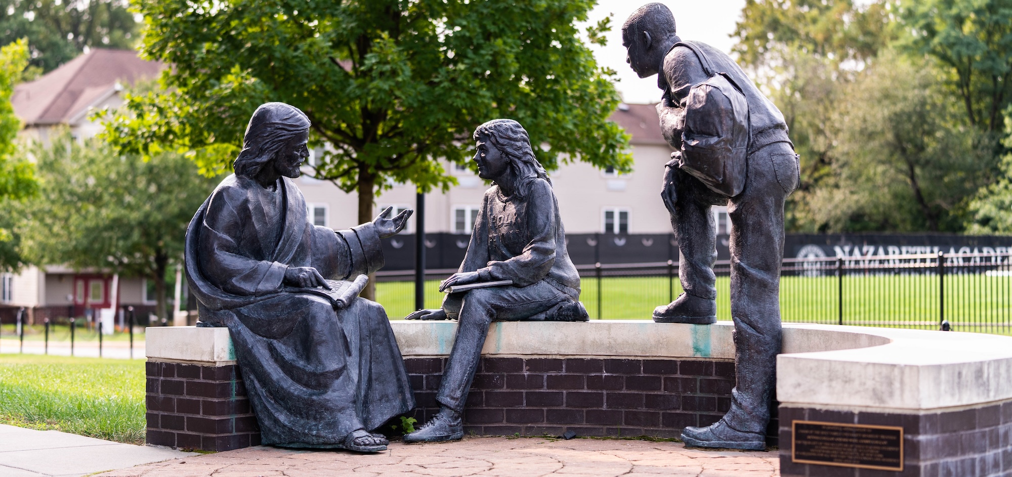 Statues on campus of Jesus teaching a female and male student