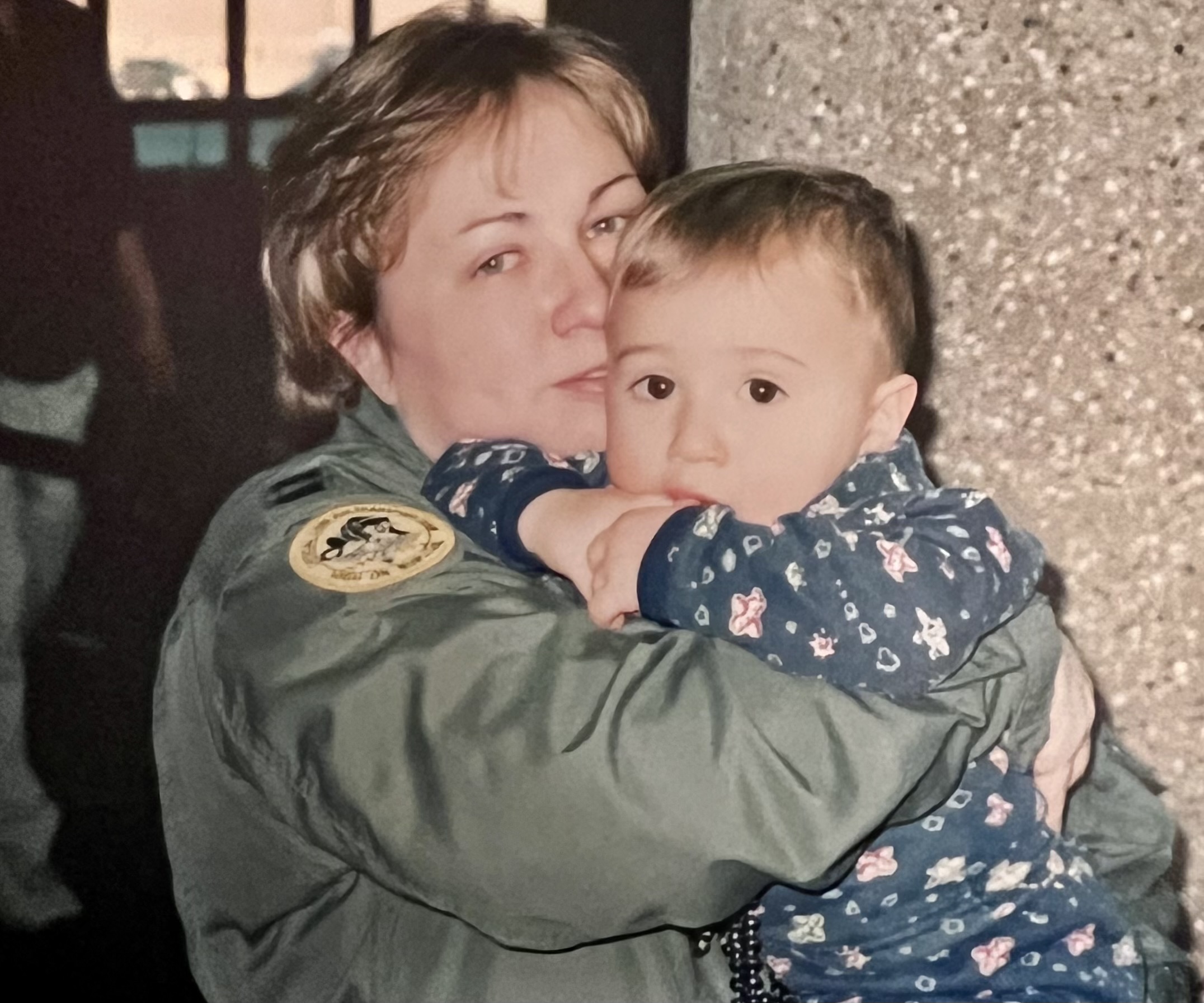 McCormick-Mejias in Air Force flight suit holding a small child