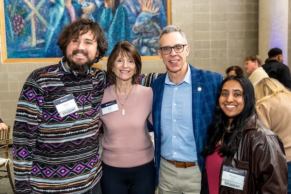 Two alums with two students at networking event on campus