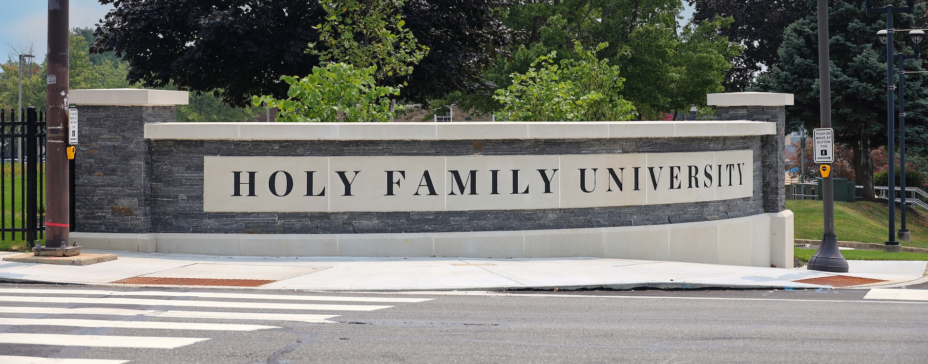 Entrance to the Philadelphia campus with sculpted wall with "Holy Family University" engraved