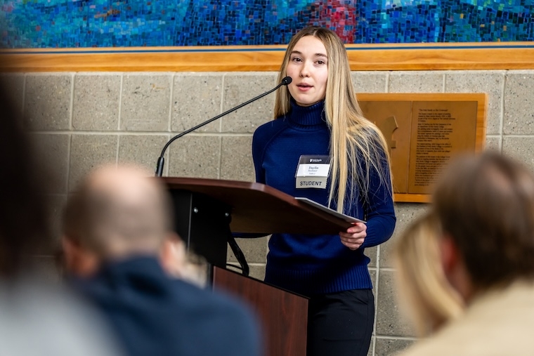 Student at podium giving a speech at an alumni event