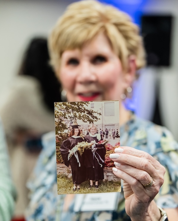 An HFU alum holds up a photo of her years ago on campus as a student