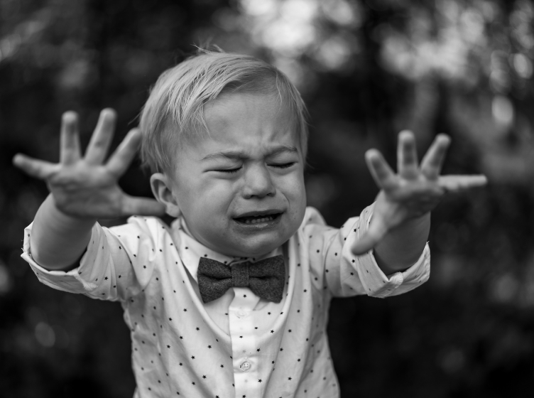 A toddler in a looking upset with tears in his eyes