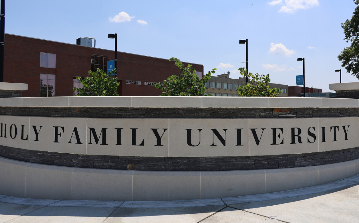A wall by the entrance to campus with "Holy Family University" engraved in it