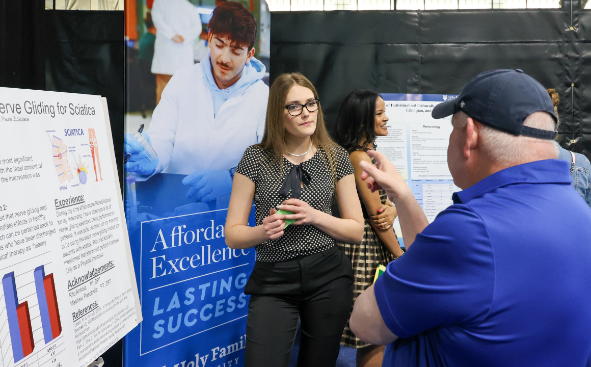 A student at a poster presentation explaining her research project